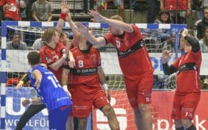 Mads Andersen wirft den Ball über die Mauer der MT Melsungen